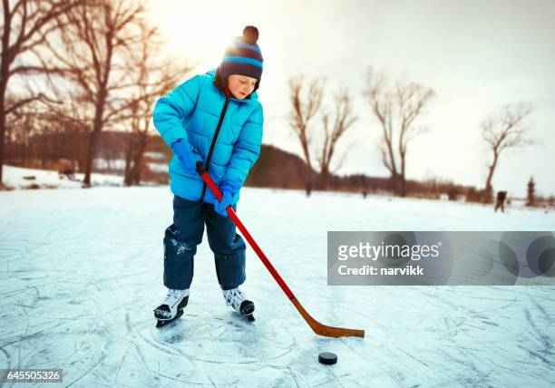 kleine junge training eishockey auf dem teich - ice hockey stock-fotos und bilder
