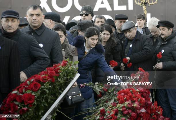 People lay flowers at the "The cry of the mother" monument on February 26, 2017 in the capital Baku, during a rally to mark the 25th anniversary of...