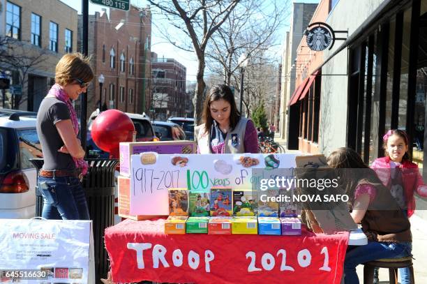 Trina Sheridan watches as her her daughters Molly age 13, and Edie age 5, sell Girl Scout cookies in Chicago on February 19, 2017. On a sunny Sunday...