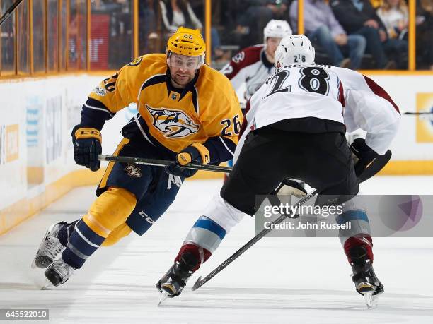 Harry Zolnierczyk of the Nashville Predators skates against Patrick Wiercioch of the Colorado Avalanche during an NHL game at Bridgestone Arena on...