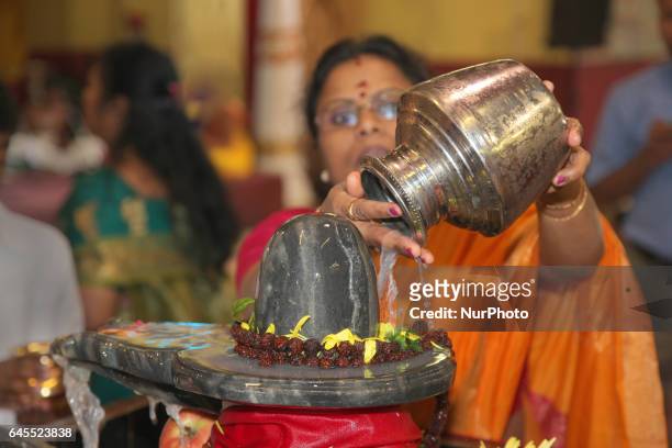 Tamil Hindu devotee offers prayers by pouring milk over a Shiva Lingam during the Maha Shivaratri Festival at a Tamil Hindu temple in Ontario,...