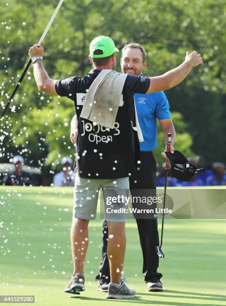 Darren Fichardt of South Africa celebrates with his caddie after winning The Joburg Open during completion of the suspended third and final round of...