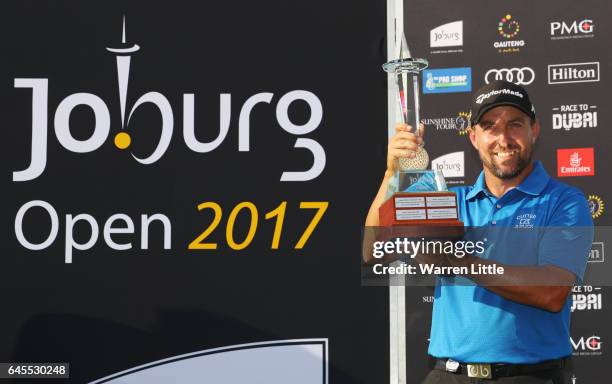 Darren Fichardt of South Africa holds the trophy as he celebrates winning The Joburg Open during completion of the suspended third and final round of...