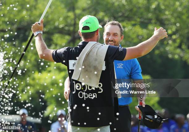 Darren Fichardt of South Africa celebrates with his caddie after winning The Joburg Open during completion of the suspended third and final round of...