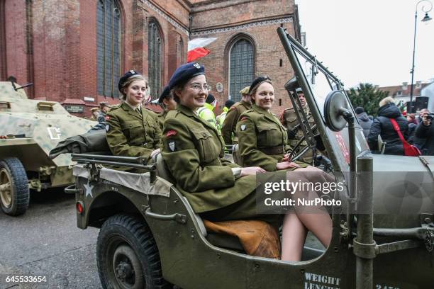 Young female history reenactors dressed as Cursed soldiers are seen in the Jeep Willys MB car during the Cursed soldiers Day parade on 26 February...