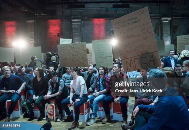 Spectators hold posters at a campaign event for Martin Schulz, chancellor candidate of the German Social Democrats on February 27, 2017 in Leipzig,...