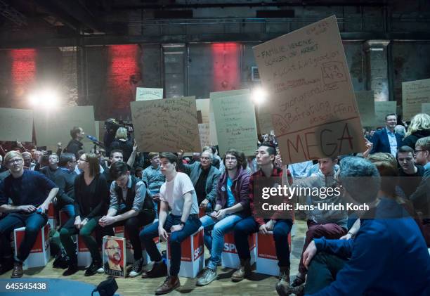 Spectators hold posters at a campaign event for Martin Schulz, chancellor candidate of the German Social Democrats on February 27, 2017 in Leipzig,...