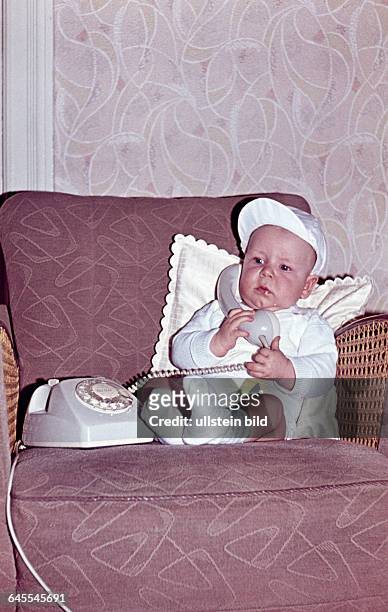 60er Jahre, Baby im Sessel mit Telefon