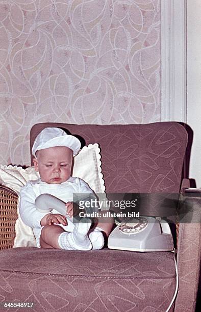 60er Jahre, Baby im Sessel mit Telefon