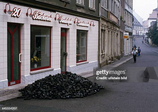 Sachsen, Wurzen: Kohlehaufen vor der Bäckerei Konditorei Rudolph in der Wenceslaigasse 20November 1990