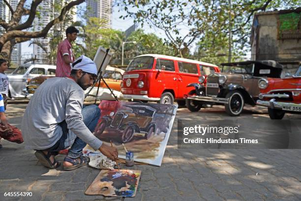 An artist paints one of the vintage cars on canvas during the display and inspection of Vintage Cars at Mahalaxmi Race Course, on February 25, 2017...