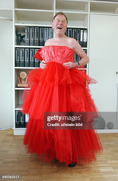 Der Intendant des Brecht Ensemble BE in Berlin , im roten Kleid aus dem Fundus , das zur Versteigerung freigegeben ist, in dem Moment , als er gerade...