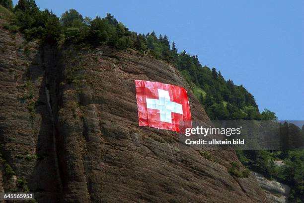 Der 01. August ist Schweizer Feiertag, hier am Vierwaldstaetter Seeist die Schweizer Flagge an einem Felsmassiv ca. 1700 m in Naehe desOrtes Vitznau...