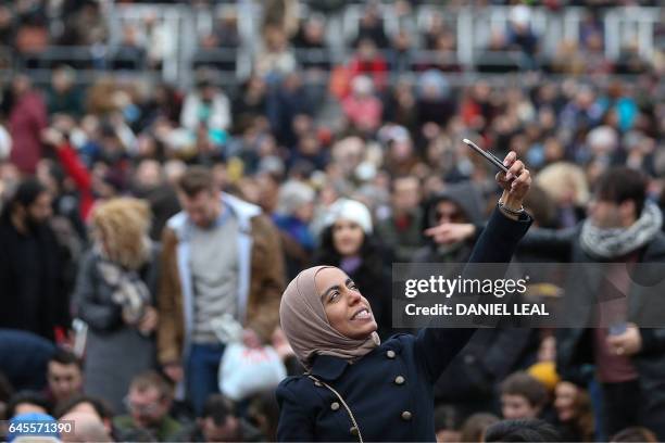 Woman takes a selfie photograph as crowds gather in Trafalgar Square for the public screening for the film 'The Salesman' in central London on...