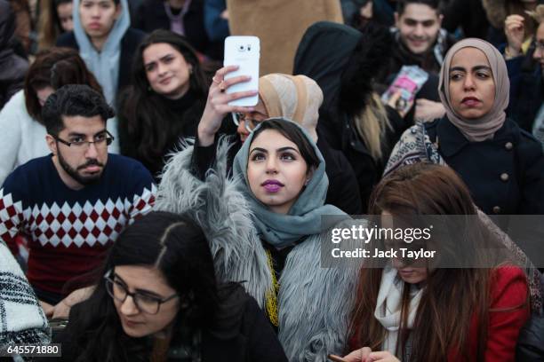 Young woman takes a picture on her phone as thousands gather to watch a free screening and UK premier of Iranian film The Salesman in Trafalgar...