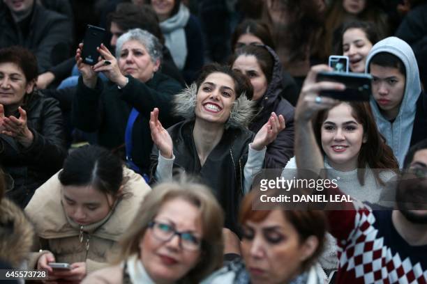 Woman smiles in the crowd as people gather in Trafalgar Square for the public screening for the film 'The Salesman' in central London on February 26,...