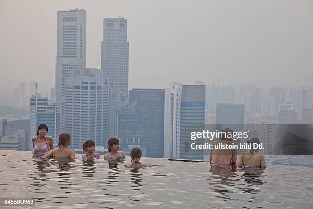 Guests relax at the Infinity Pool at the famous Marina Bay Sands Hotel SkyPark, Singapore