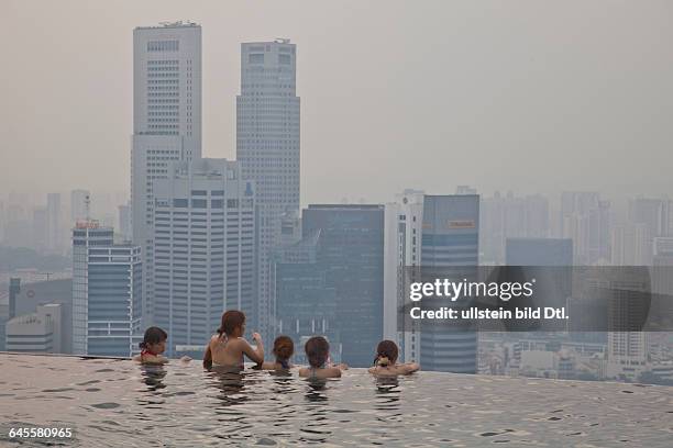 Guests relax at the Infinity Pool at the famous Marina Bay Sands Hotel SkyPark, Singapore