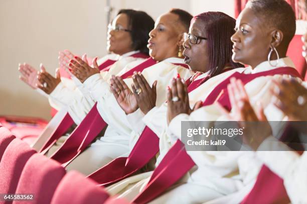 group of mature black women in church robes - gospel choir stock pictures, royalty-free photos & images