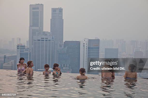 Guests relax at the Infinity Pool at the famous Marina Bay Sands Hotel SkyPark, Singapore