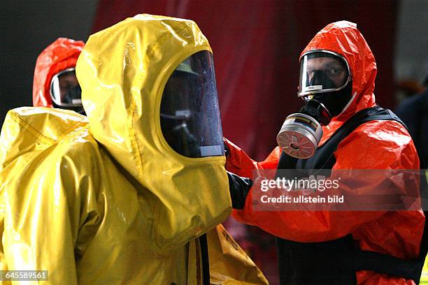 Gefahrgutausbildung der Berufsfeuerwehr Muenchen.Unfall mit gefaehrlichen Guetern.EIn Feuerwehrmann im Chemieschutzanzug wird von einem...