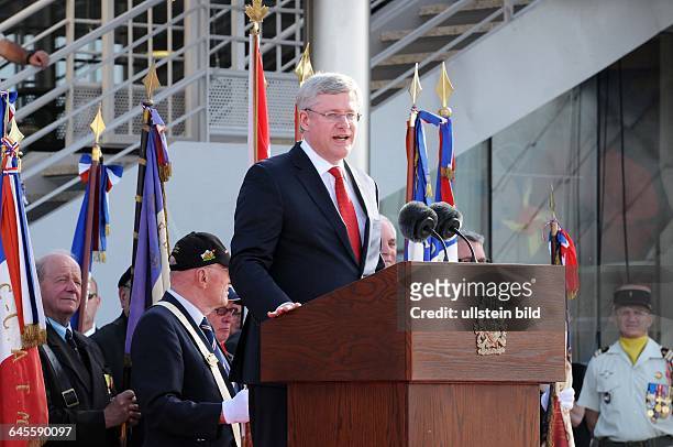June 6 Courseulles, Normandy, France. Canada's prime minister is delivering his speech. Prince Charles, his wife Camilla, and the prime minister of...