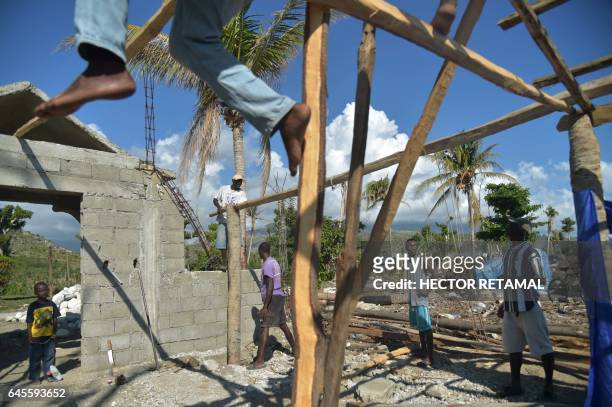 Men work rebuilding an evangelic church, destroyed by Hurricane Matthew, in the village of Labeyi in the commune of Chardonnieres, southwest Haiti,...