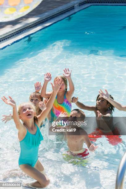 multi-ethnic group of children playing in swimming pool - kids pool games stock pictures, royalty-free photos & images