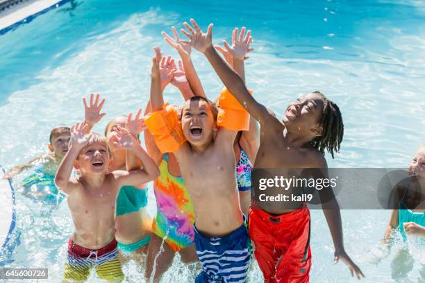 multi-ethnischen gruppe von kindern beim spielen im schwimmbad - kids pool games stock-fotos und bilder