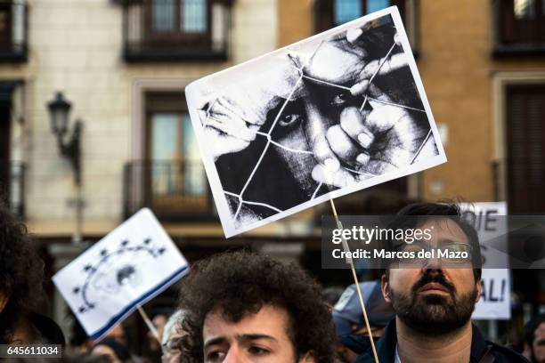 Man carrying a picture of a refugee during a protest in front of the Ministry of Foreign Affairs against EU policies with refugees.