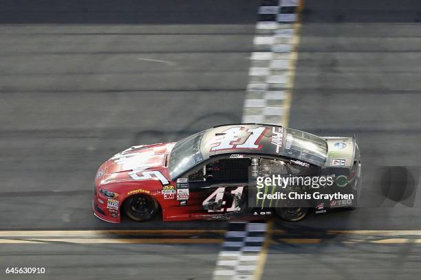 Kurt Busch, driver of the Haas Automation/Monster Energy Ford, takes the checkered flag to win the 59th Annual DAYTONA 500 at Daytona International...