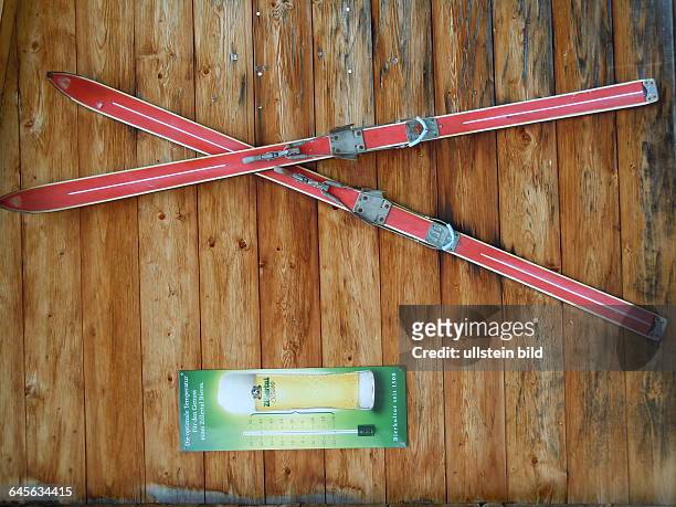Zwei gekreuzte Skier sind neben einer Bierwerbung an der Holzwand einer Berghütte angebracht, aufgenommen am 18. August 2015 in den Zillertaler Alpen...