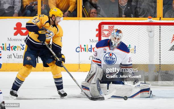 Cam Talbot of the Edmonton Oilers makes the save against Colin Wilson of the Nashville Predators during an NHL game at Bridgestone Arena on February...