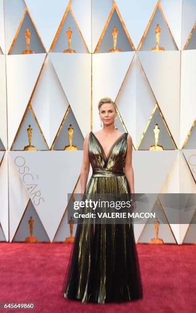 Actress Charlize Theron poses as she arrives on the red carpet for the 89th Oscars on February 26, 2017 in Hollywood, California. / AFP / VALERIE...