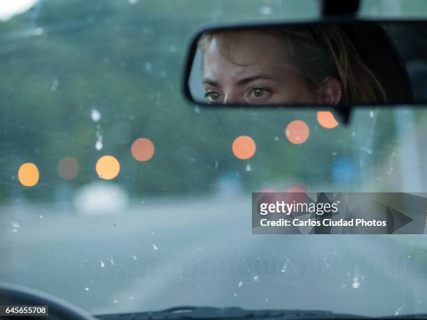 tired woman driving at dusk on a highway - windshield foto e immagini stock