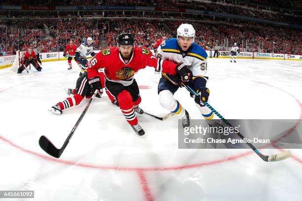 Marcus Kruger of the Chicago Blackhawks and Magnus Paajarvi of the St. Louis Blues watch for the puck in the first period at the United Center on...