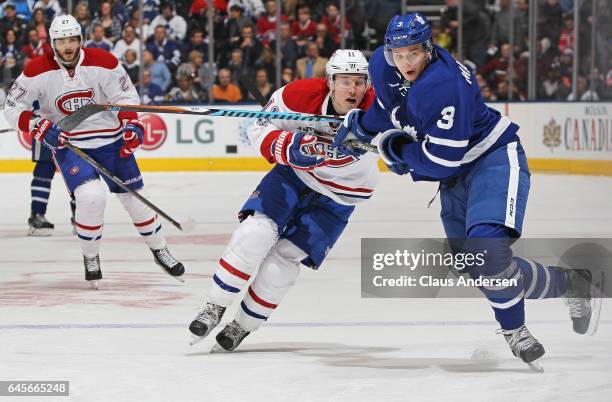 Brendan Gallagher of the Montreal Canadiens is held up by Alexey Marchenko of the Toronto Maple Leafs during an NHL game at the Air Canada Centre on...