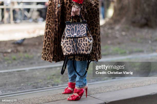 Linda Tol wearing red hoody and leopard print coat and backpack, red heels outside Dolce & Gabbana during Milan Fashion Week Fall/Winter 2017/18 on...