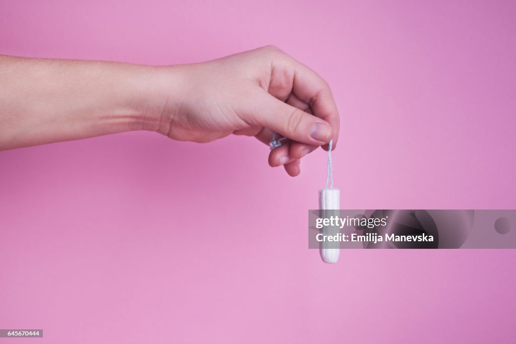 Human hand holding tampon