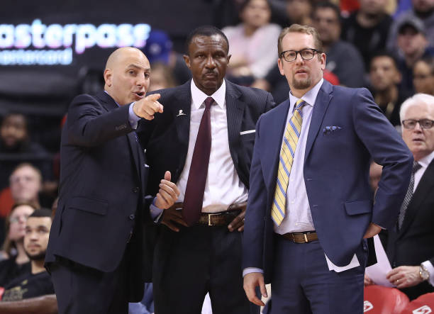 Head coach Dwane Casey of the Toronto Raptors listens to assistant coaches Rex Kalamian and Nick Nurse against the Portland Trail Blazers during NBA...