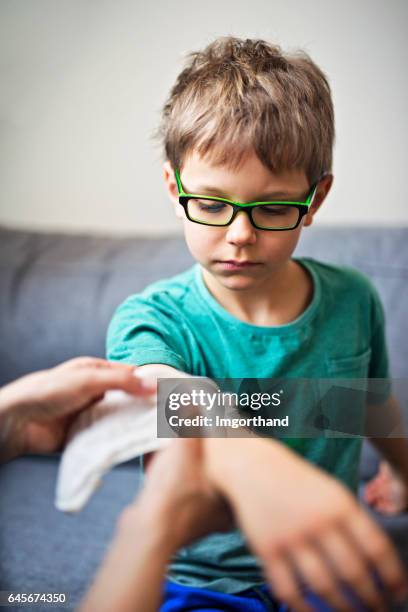 mother tending to her son's wounded arm - elbow bandage stock pictures, royalty-free photos & images