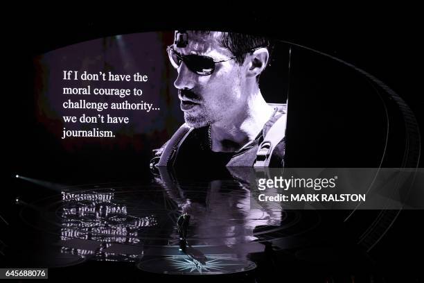 British singer Sting performs on stage in front of a portrait of US reporter James Foley at the 89th Oscars on February 26, 2017 in Hollywood,...
