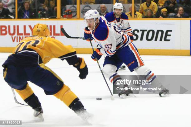 Edmonton Oilers center Connor McDavid skates with the puck as Nashville Predators right wing Viktor Arvidsson defends during the NHL game between the...