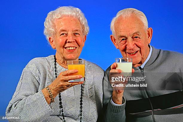 Senioren-Ehepaar trinkt Milch und Orangensaft