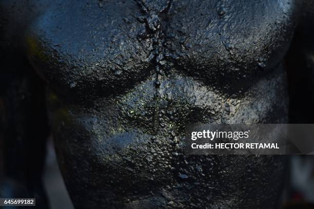 Reveler with body painted with a mixture of cane sugar and coal, performs during the 2017 National Carnival Parade on February 26 in the city of Les...