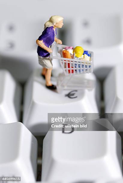 Frau mit Einkaufswagen auf Computertastatur, Online-Shopping