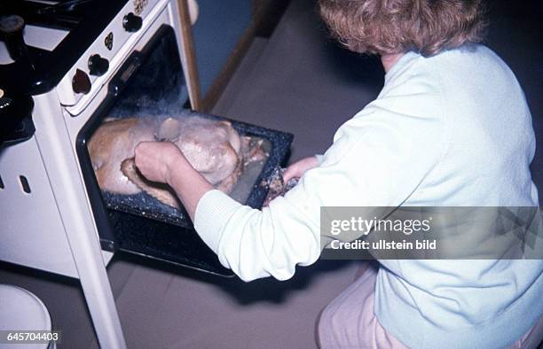 Ca. 1950, Frau brät eine Gans im Backofen