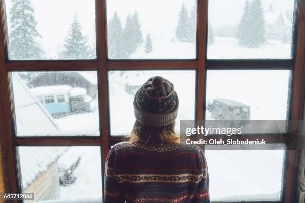 woman looking in the window in winter - winter weather stock pictures, royalty-free photos & images