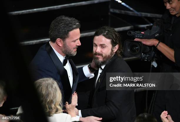 Winner for Best Actor "Manchester By The Sea" Casey Affleck is embraced by his brother Ben Affleck on stage at the 89th Oscars on February 26, 2017...