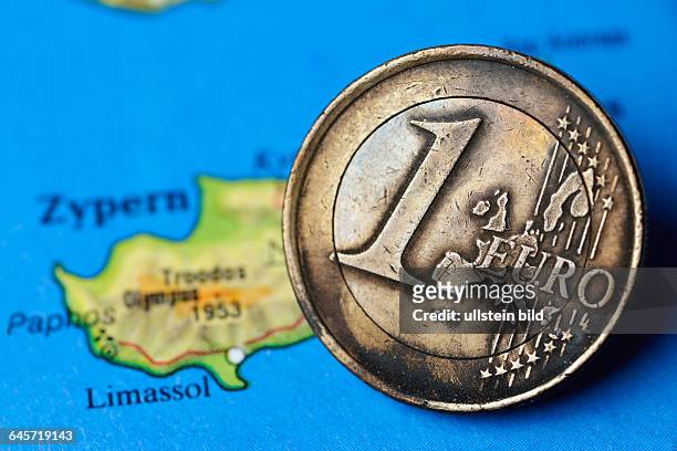 Angebrannte Ein-Euro-Münze auf Zypern-Landkarte, Eurokrise